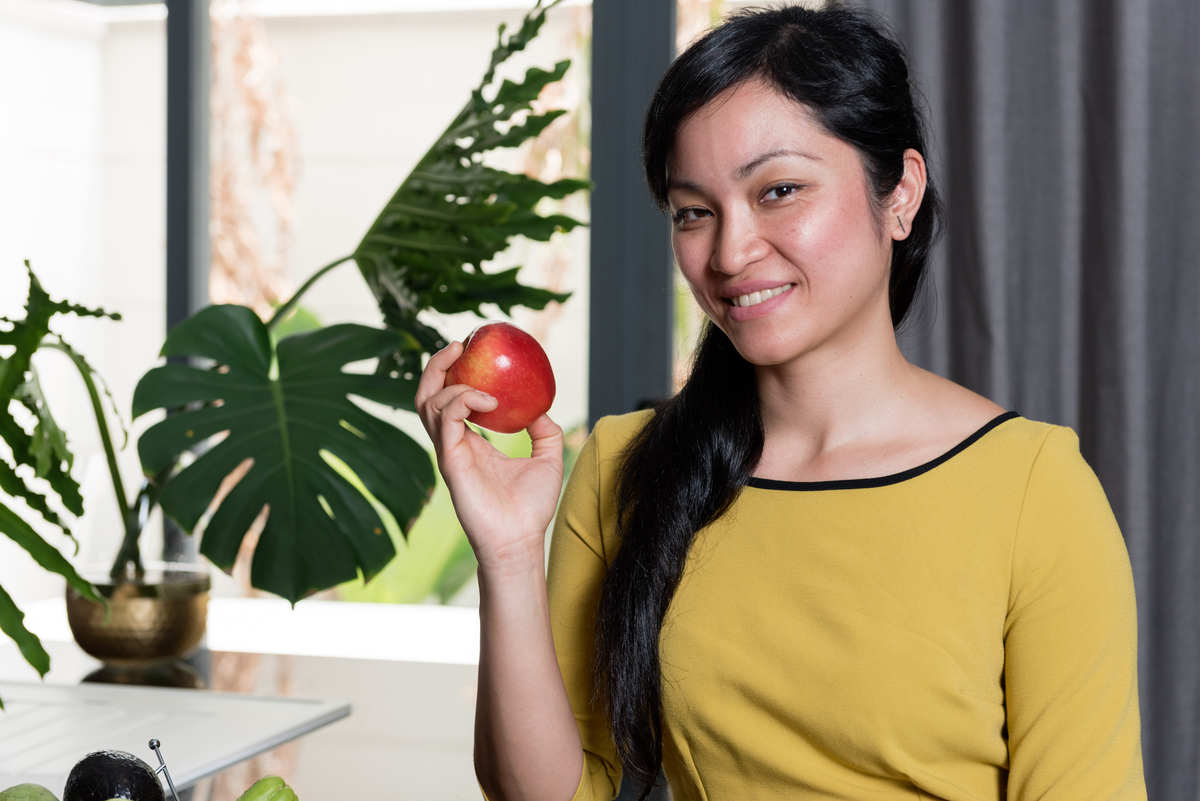 english speaking nutritionist and holistic health coaching Linh Le Niaria with apple